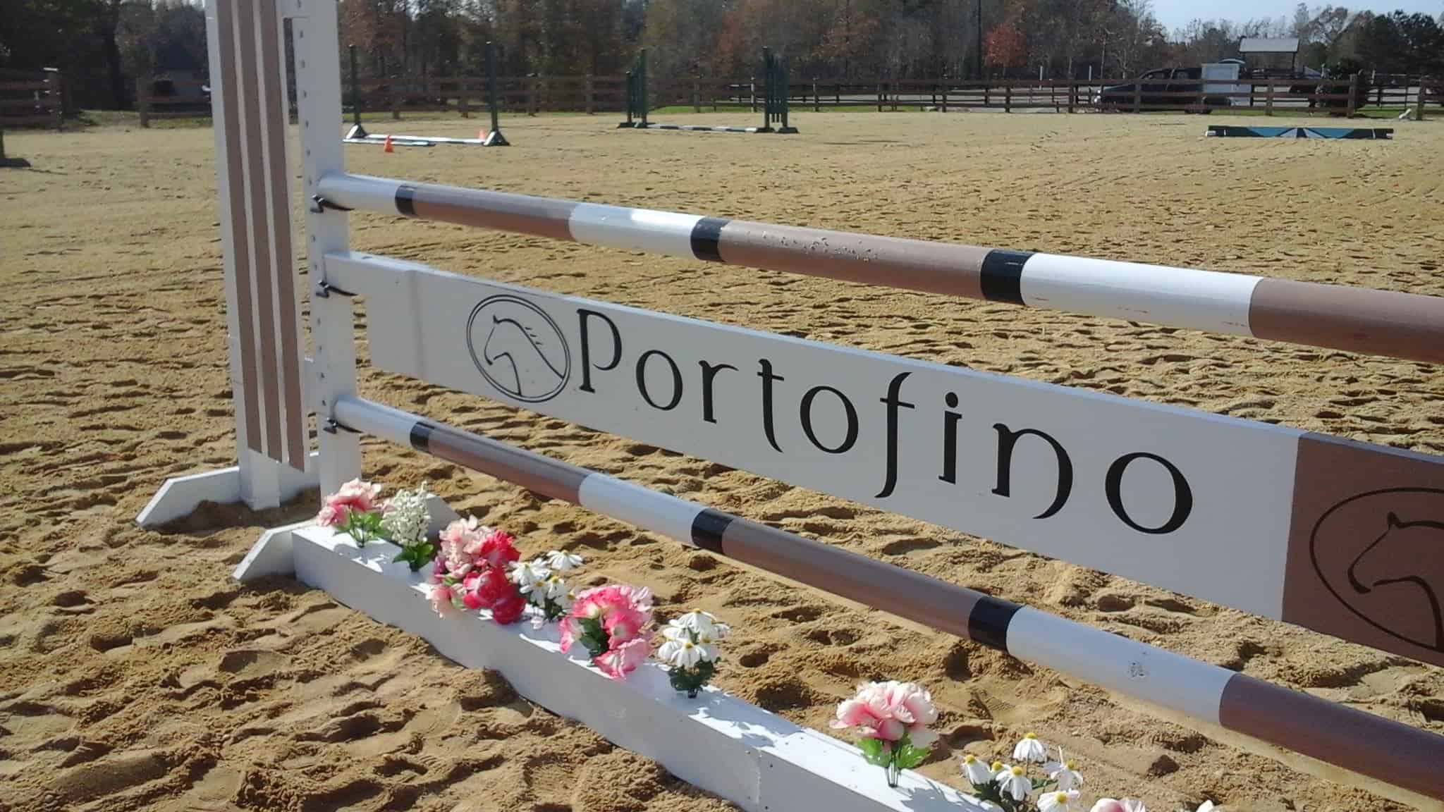Stadium jump with Portofino Equestrian Center logo.